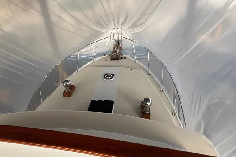 Oasis Yacht Photos Pics 1987 Wilbur 38 boat under protective cover, showcasing deck and railings.