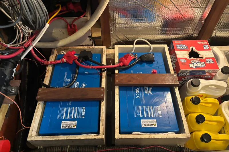 Oasis Yacht Photos Pics Battery setup in a 1987 Wilbur 38 boat, featuring wiring and storage compartments.