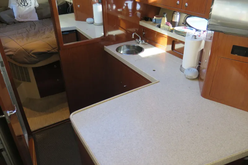  Yacht Photos Pics 2006 Regal Commodore 3880 yacht interior with kitchen and cozy bedroom.