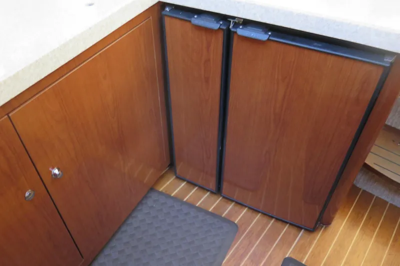  Yacht Photos Pics 2006 Regal Commodore 3880 yacht kitchen with wooden cabinets and compact refrigerator.