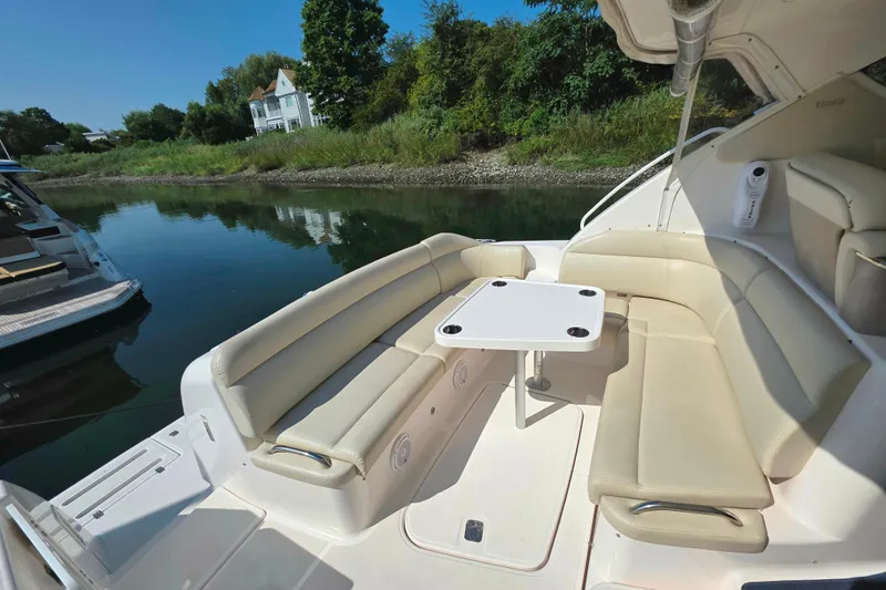 Living Benefit Yacht Photos Pics 2007 Tiara Yachts 3900 Sovran with beige seating and table, docked by lush greenery.