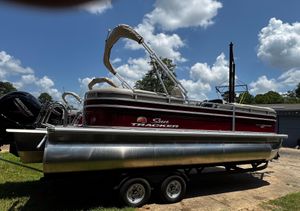 2024 Sun Tracker Party Barge 22 XP3 pontoon boat on trailer under a blue sky.