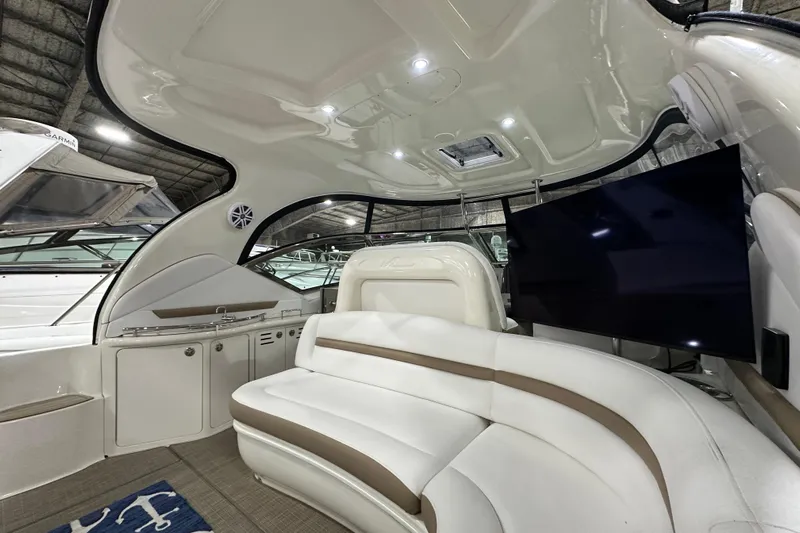 Lilley Pad Yacht Photos Pics Interior of 2007 Sea Ray 44 Sundancer yacht with white seating and mounted TV.