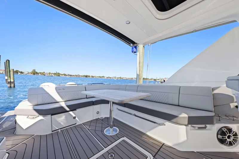  Yacht Photos Pics 2023 Sea Ray SLX 400 Outboard boat interior with elegant seating and table, overlooking serene waters.