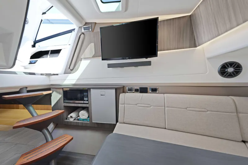  Yacht Photos Pics Interior of 2023 Sea Ray SLX 400 Outboard with TV, sofa, and kitchenette.