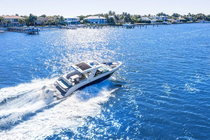  Yacht Photos Pics 2023 Sea Ray SLX 400 Outboard cruising on a sunny, sparkling blue waterway.