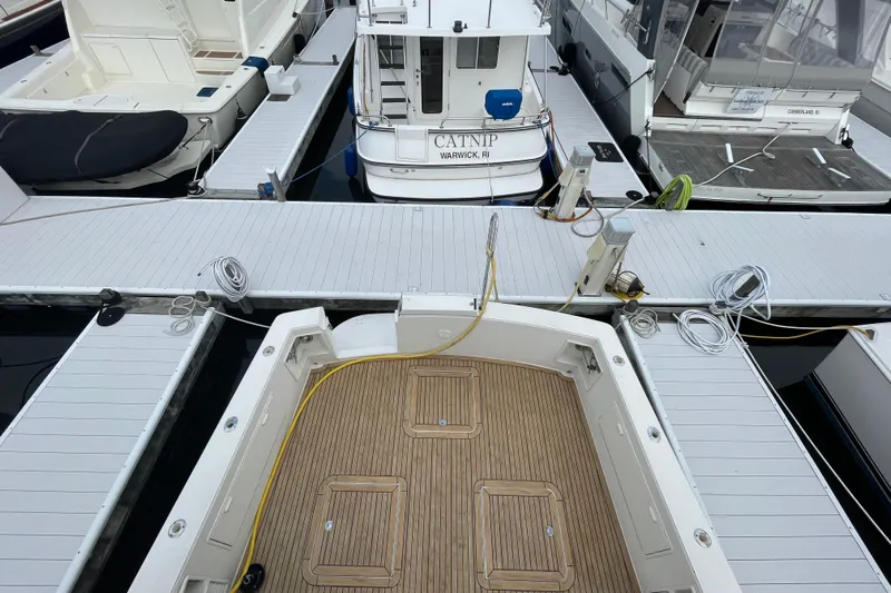 Reel It In Yacht Photos Pics Docked Ocean Yachts 40 Super Sport, 2003 model, with wooden deck and marina view.