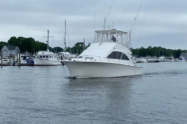 Reel It In Yacht Photos Pics 2003 Ocean Yachts 40 Super Sport cruising in a marina with other boats.
