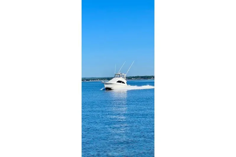 Reel It In Yacht Photos Pics 2003 Ocean Yachts 40 Super Sport cruising on a clear blue sea.