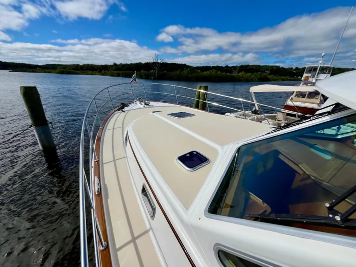 Calamity Jane Yacht Photos Pics 2018 Sabre 45 Salon Express yacht on a serene lake under a blue sky.