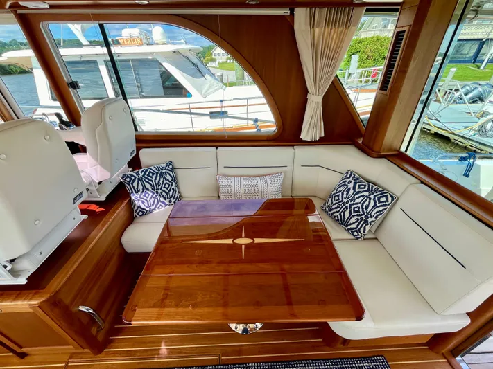 Calamity Jane Yacht Photos Pics Interior of 2018 Sabre 45 Salon Express with elegant seating and wooden table.