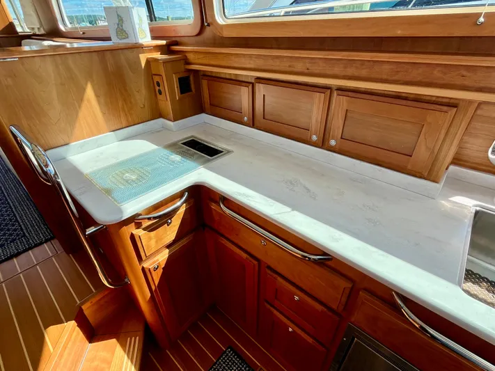 Calamity Jane Yacht Photos Pics Luxurious 2018 Sabre 45 Salon Express yacht interior with elegant wood cabinetry and sleek countertops.