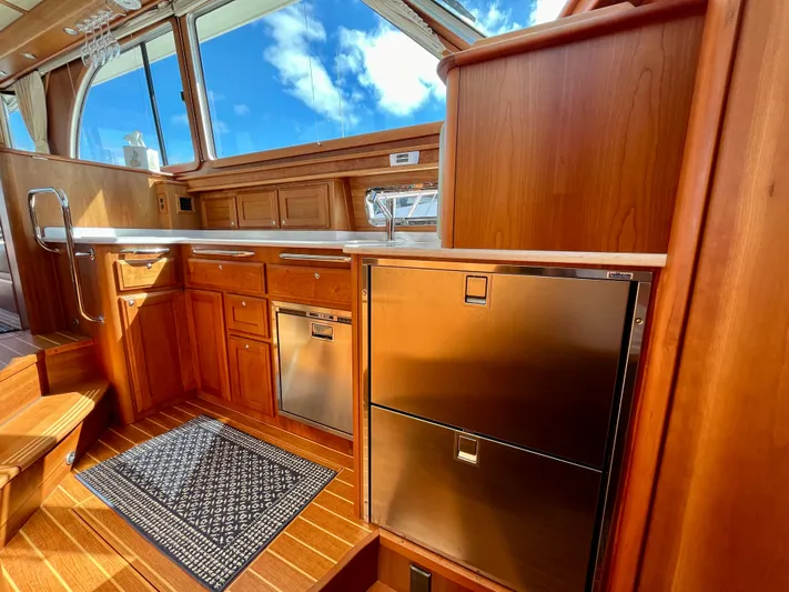 Calamity Jane Yacht Photos Pics Interior of 2018 Sabre 45 Salon Express yacht with wooden cabinetry and stainless steel appliances.