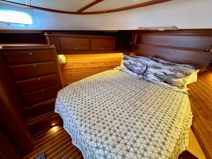 Calamity Jane Yacht Photos Pics Luxurious bedroom interior of 2018 Sabre 45 Salon Express yacht with wood paneling.
