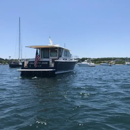 Calamity Jane Yacht Photos Pics 2018 Sabre 45 Salon Express boat on water, clear sky, other boats in background.