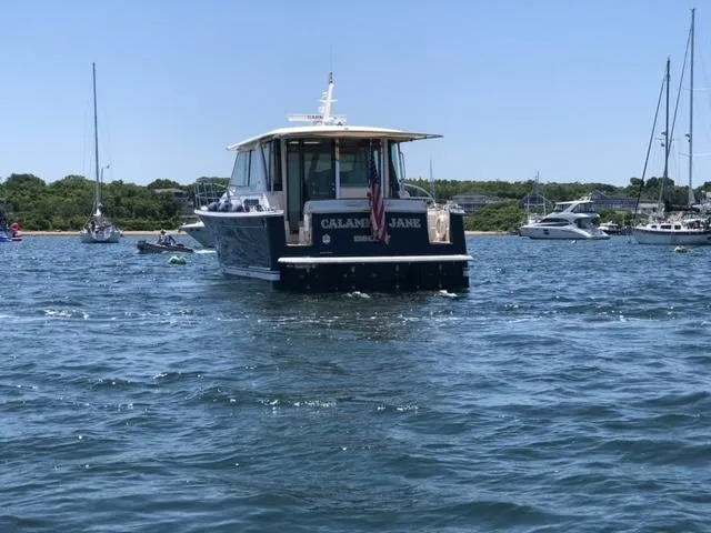 Calamity Jane Yacht Photos Pics 2018 Sabre 45 Salon Express boat on water, surrounded by other boats.