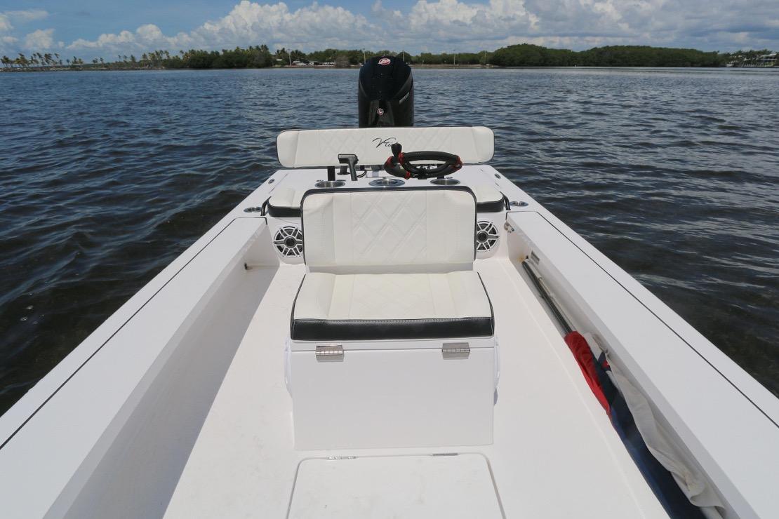 2024 Vtech 18 boat interior with white seating, steering wheel, and water view.
