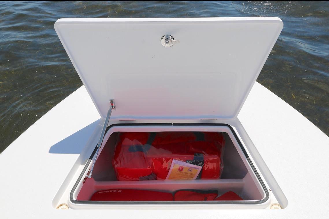 Open storage compartment on Vtech 18 boat, 2024 model, with life jackets inside.