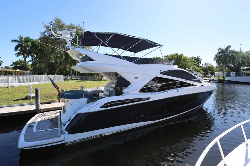  Yacht Photos Pics 2016 Sunseeker Manhattan 55 yacht docked by a lush, tropical waterfront.