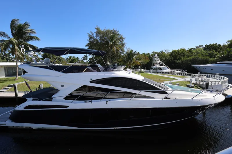  Yacht Photos Pics 2016 Sunseeker Manhattan 55 yacht docked by palm trees under clear blue sky.