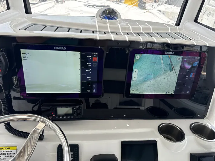  Yacht Photos Pics 2022 Tidewater 2700 Carolina Bay dashboard with dual Simrad displays and steering wheel.