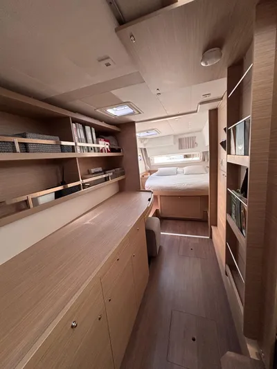  Yacht Photos Pics Luxurious interior of 2024 Lagoon 42 yacht with modern wood finish and cozy bedroom.
