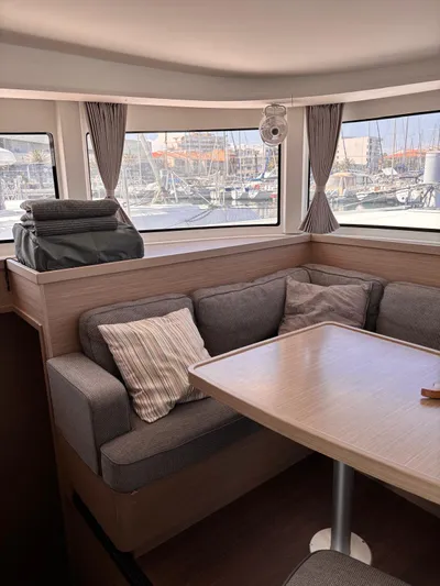  Yacht Photos Pics Interior of 2024 Lagoon 42 catamaran with cozy seating and marina view.