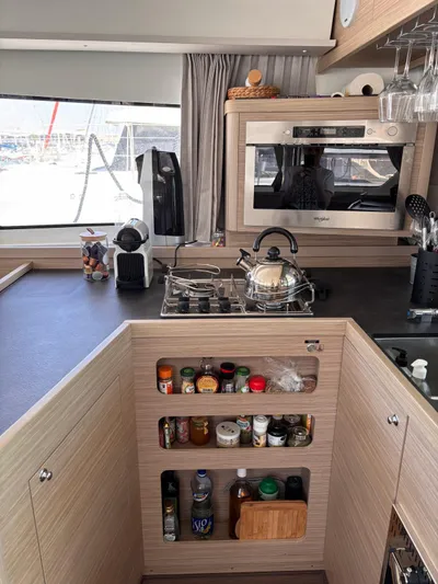  Yacht Photos Pics Modern kitchen interior of 2024 Lagoon 42 yacht with stove, oven, and storage.
