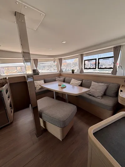  Yacht Photos Pics Modern interior of 2024 Lagoon 42 catamaran with cozy seating and dining area.