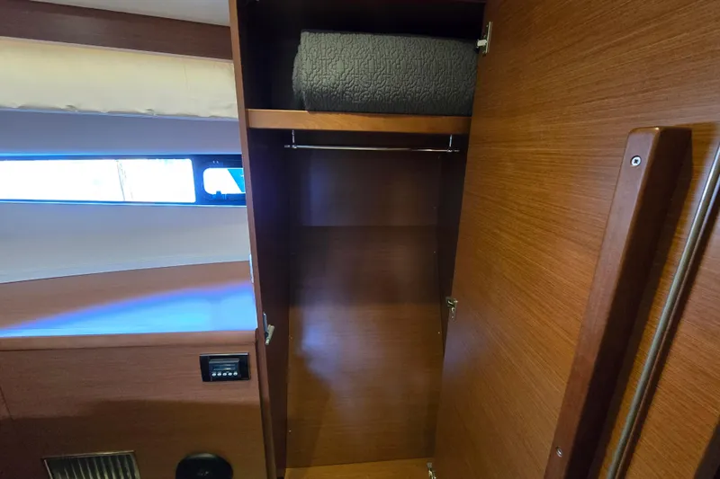 What A Day Yacht Photos Pics Wooden closet interior on a 2013 Prestige 500 yacht, featuring a folded blanket.