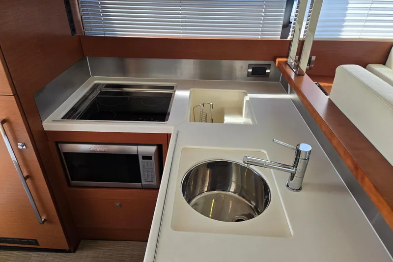 What A Day Yacht Photos Pics Modern kitchen area in a 2013 Prestige 500 yacht with sink, stove, and microwave.