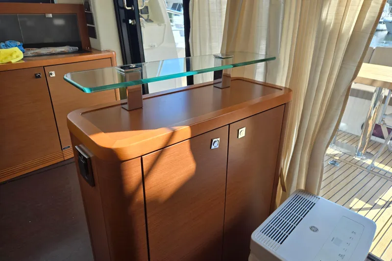 What A Day Yacht Photos Pics Interior of 2013 Prestige 500 yacht with wooden cabinetry and glass shelf.