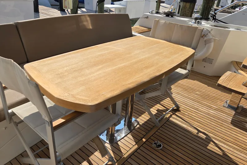 What A Day Yacht Photos Pics Teak deck dining area on 2013 Prestige 500 yacht with wooden table and cushioned seating.