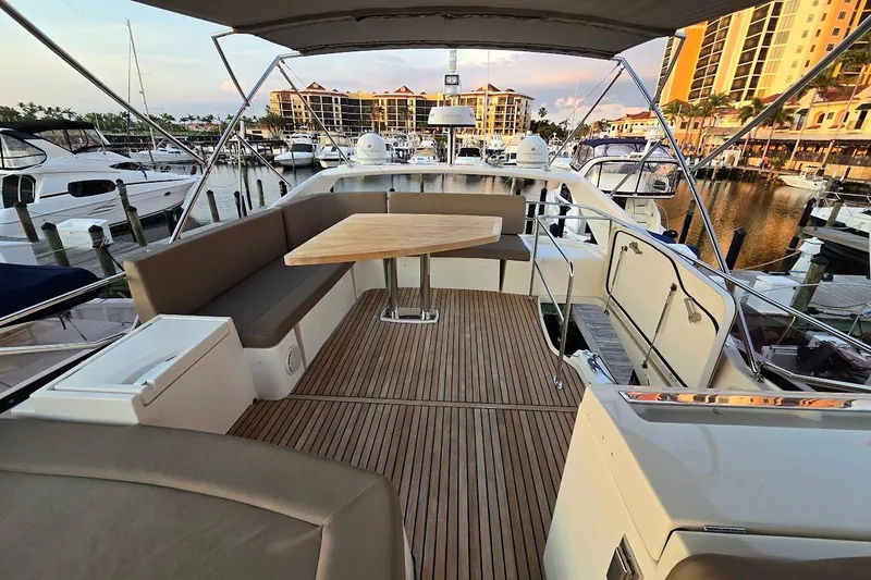 What A Day Yacht Photos Pics Flybridge of 2013 Prestige 500 yacht with seating and table, docked at marina.