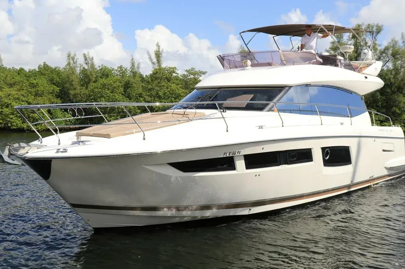 What A Day Yacht Photos Pics 2013 Prestige 500 yacht cruising on a serene waterway with lush greenery.