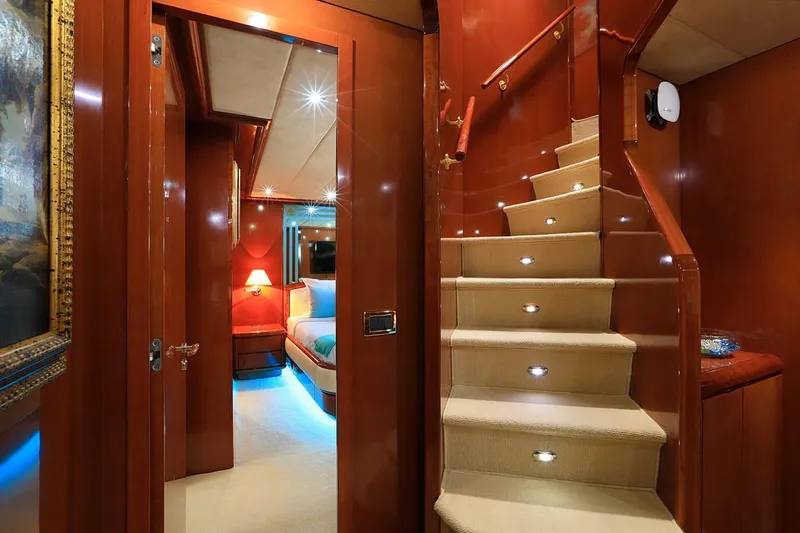 Demarest Yacht Photos Pics Luxurious interior of 2002 Falcon 106 yacht with elegant staircase and cozy bedroom.