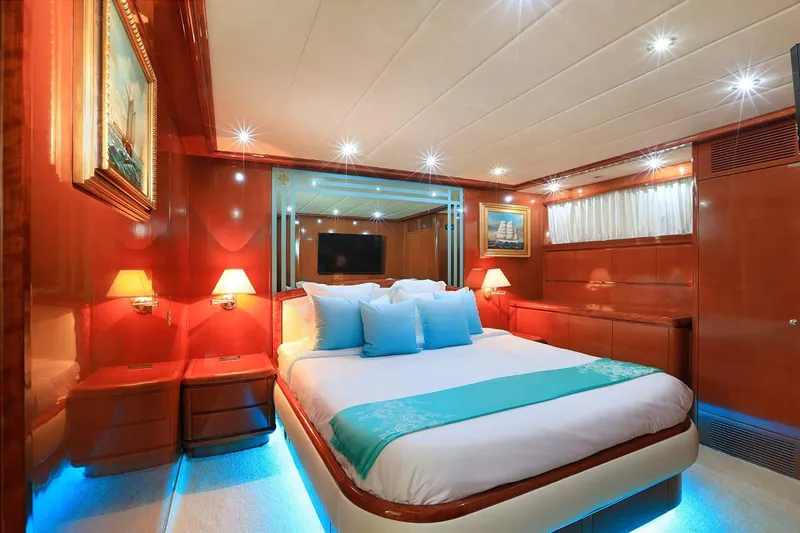 Demarest Yacht Photos Pics Luxurious bedroom interior on a 2002 Falcon 106 yacht, featuring elegant wood paneling and ambient lighting.