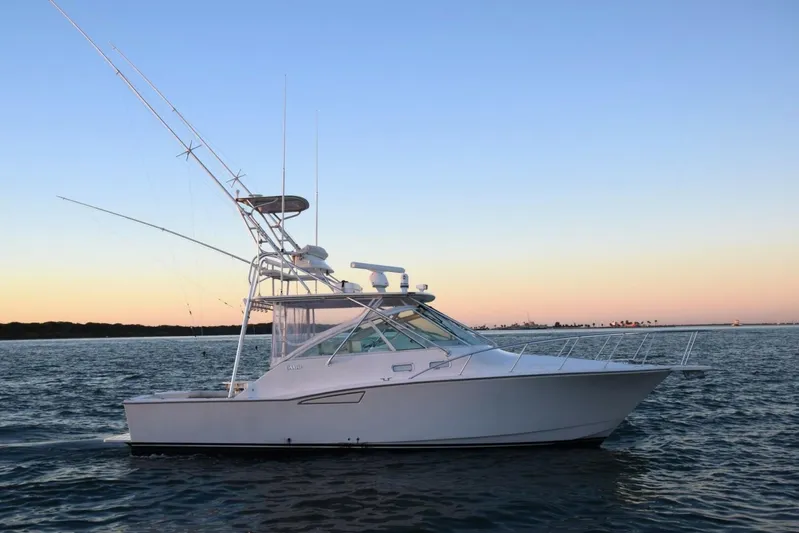 Never Again VII Yacht Photos Pics 2006 Cabo 35 Express boat on calm water at sunset.