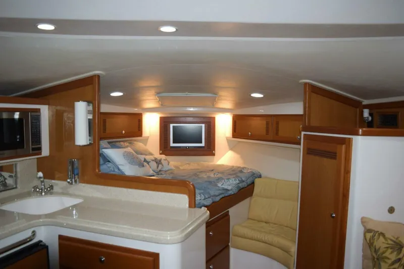 Never Again VII Yacht Photos Pics 2006 Cabo 35 Express interior with bed, kitchenette, and seating area.