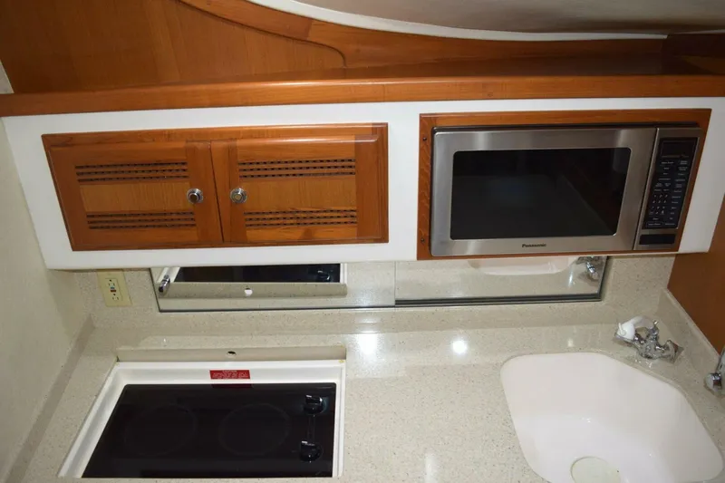 Never Again VII Yacht Photos Pics 2006 Cabo 35 Express kitchen with microwave, stove, and sink.