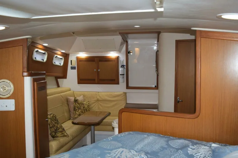 Never Again VII Yacht Photos Pics Interior of 2006 Cabo 35 Express yacht with cozy seating and wooden cabinetry.