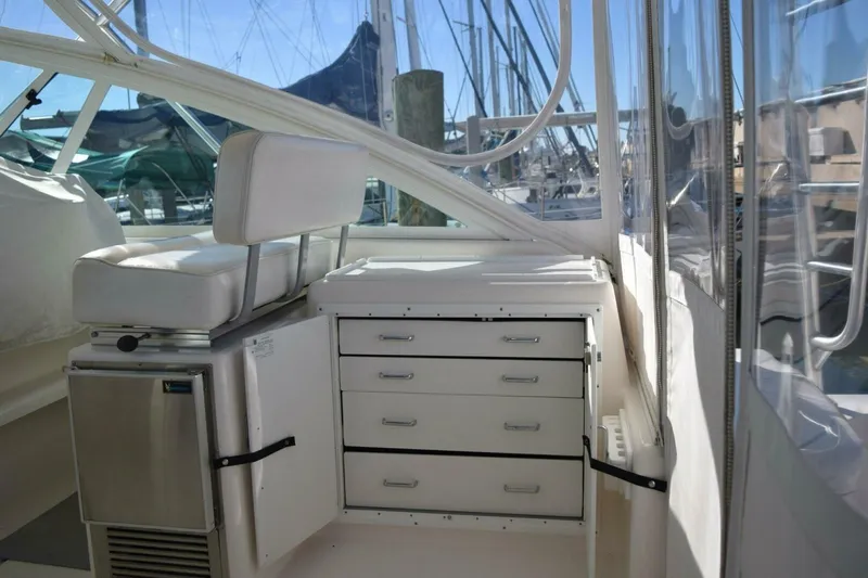 Never Again VII Yacht Photos Pics 2006 Cabo 35 Express boat interior with seating, storage drawers, and marina view.