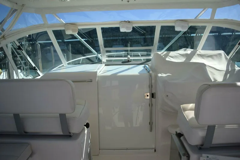 Never Again VII Yacht Photos Pics Interior view of a 2006 Cabo 35 Express boat cockpit with white seating.