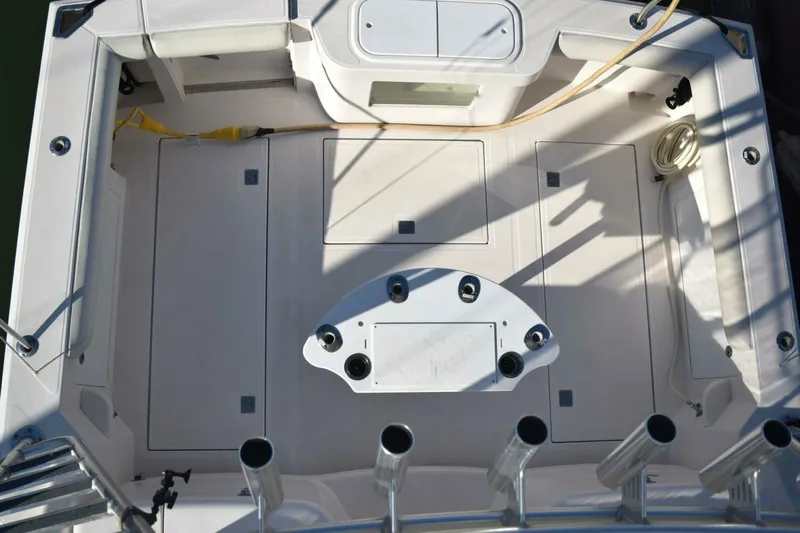 Never Again VII Yacht Photos Pics 2006 Cabo 35 Express boat deck with fishing rod holders and storage compartments.