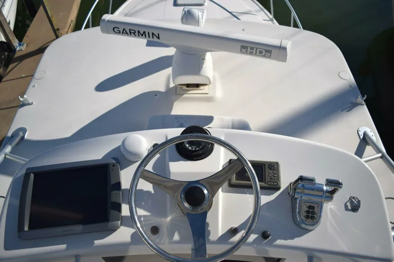 Never Again VII Yacht Photos Pics Helm of 2006 Cabo 35 Express boat with Garmin navigation system and steering wheel.