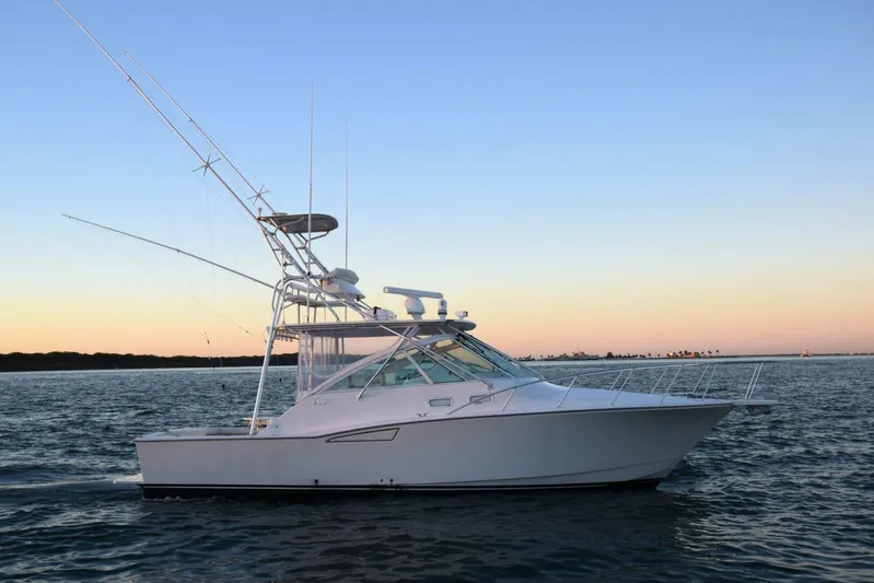 Never Again VII Yacht Photos Pics 2006 Cabo 35 Express boat on calm water at sunset.