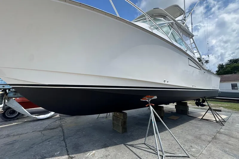 Never Again VII Yacht Photos Pics 2006 Cabo 35 Express boat on dry dock, side view under clear sky.