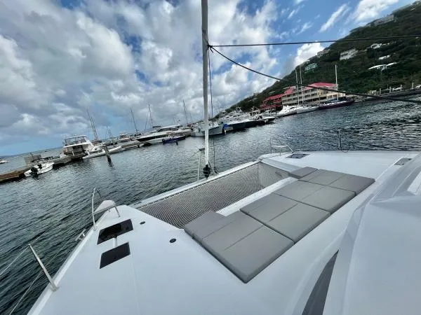 Sea The World Yacht Photos Pics 2023 Fountaine Pajot Elba 45 catamaran docked in a marina with scenic views.