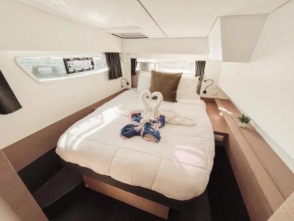 Sea The World Yacht Photos Pics Luxurious cabin interior of 2023 Fountaine Pajot Elba 45 catamaran with elegant bedding.