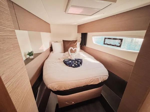 Sea The World Yacht Photos Pics Luxurious cabin interior of 2023 Fountaine Pajot Elba 45 catamaran with elegant bedding.